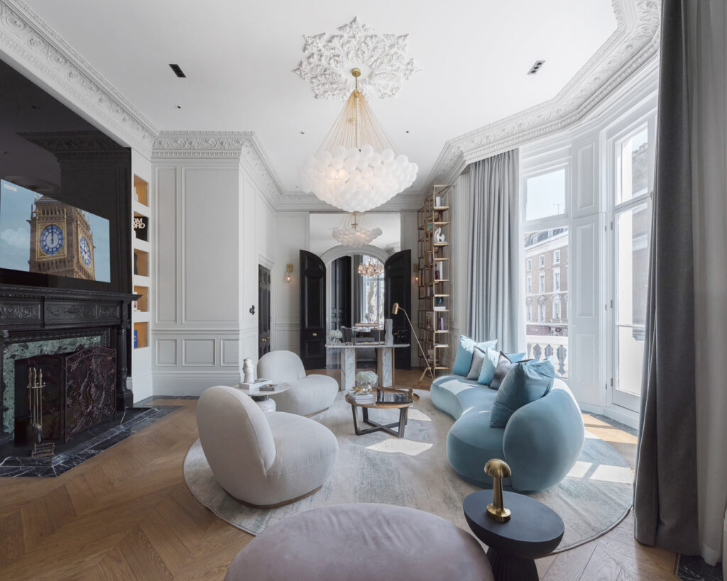 A living room with a chandelier and a white and blue sofas