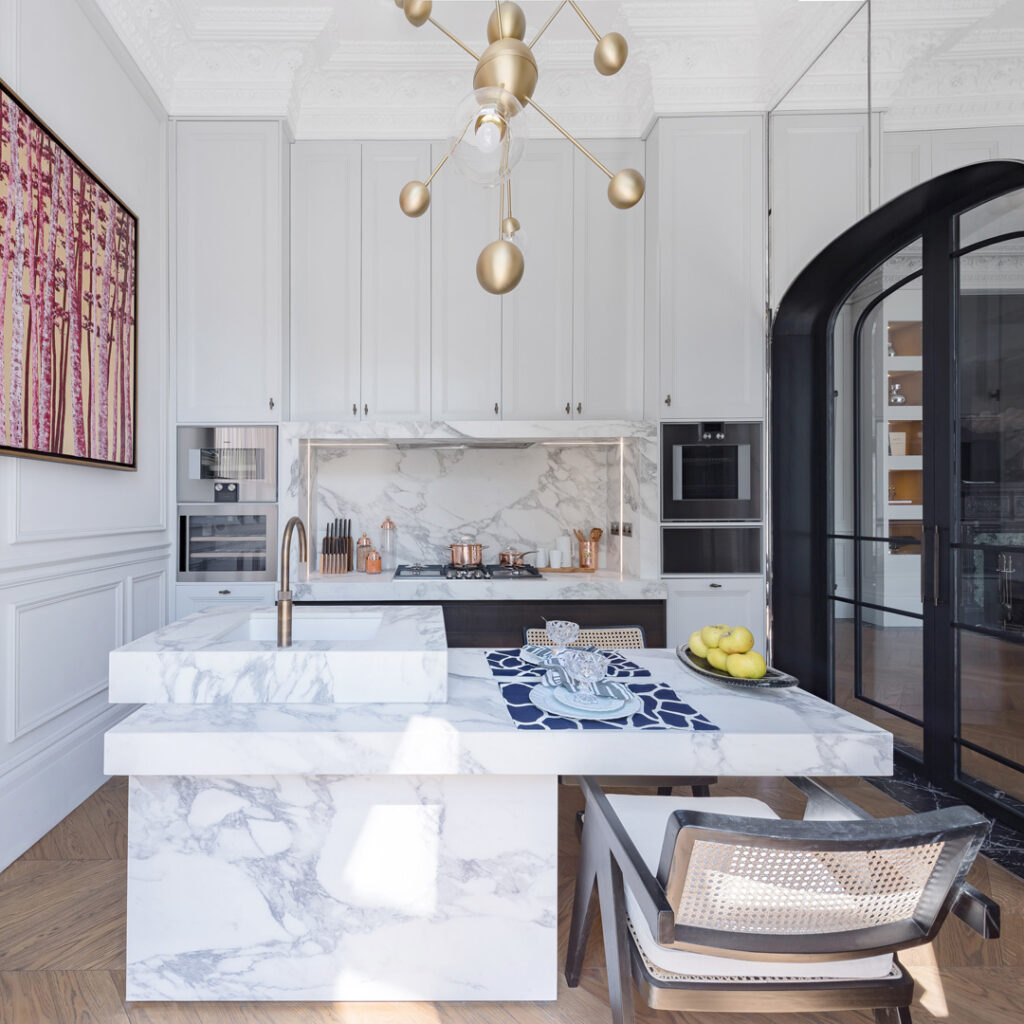 A kitchen with a marble island and a chair