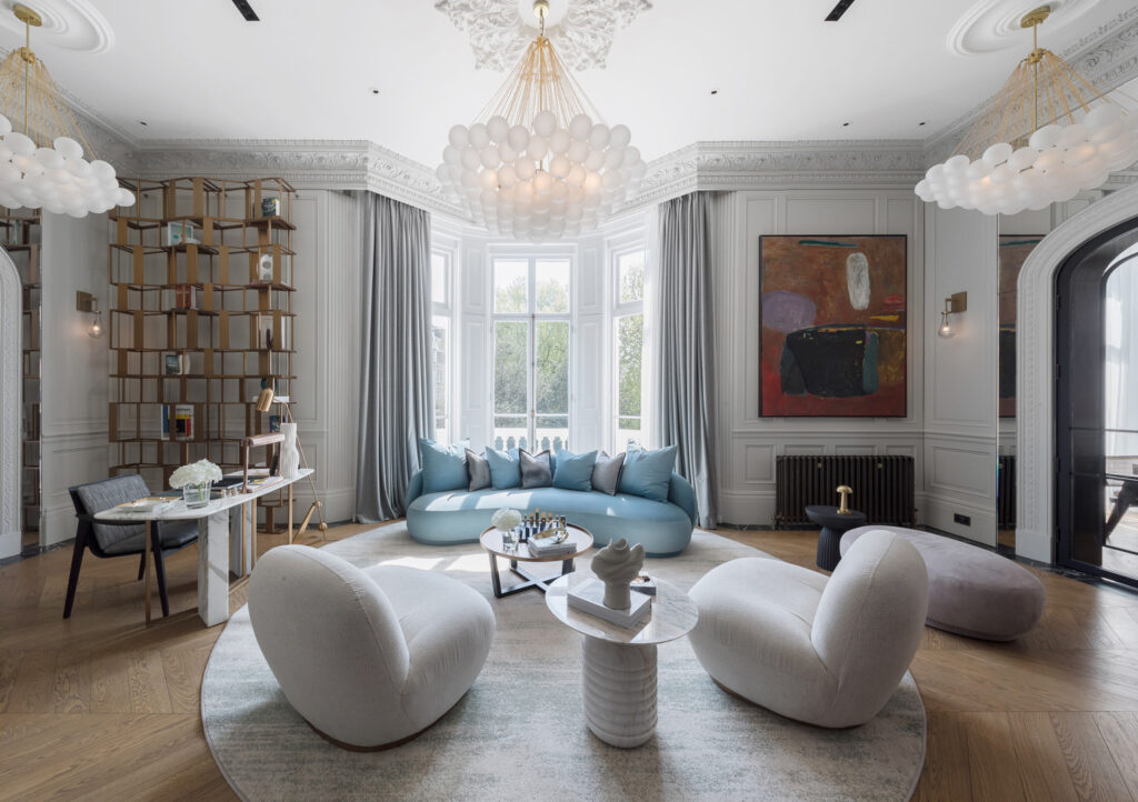 A room with two round coffee tables, sofa chairs and a chandelier