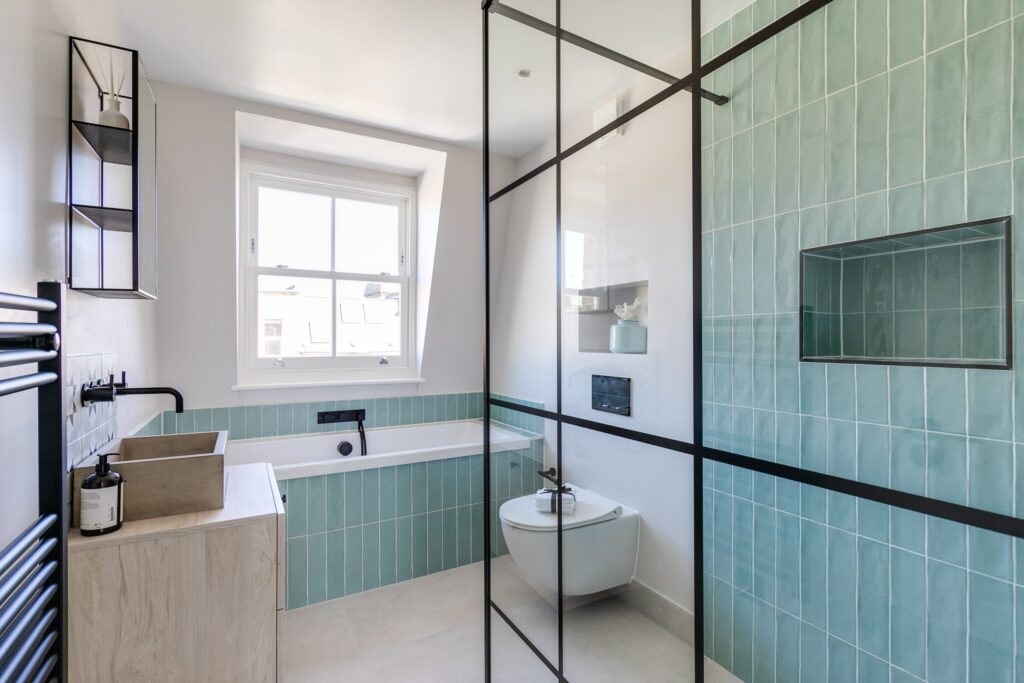 A light blue bathroom with a tub and toilet
