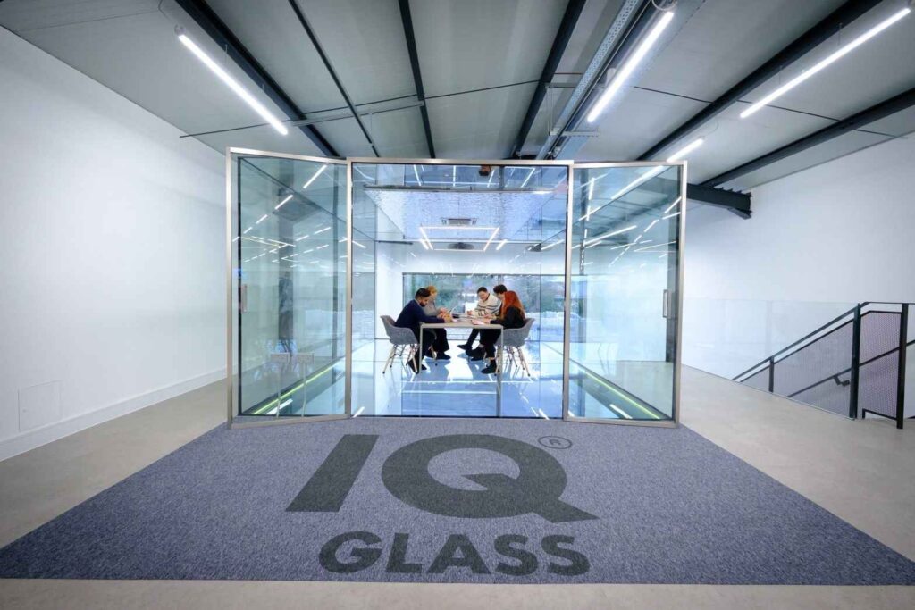 A group of people sitting at a table in a glass room