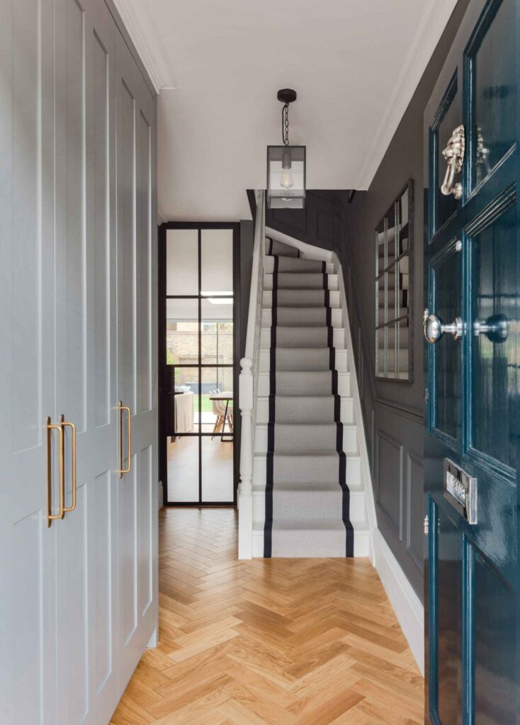 A hallway with stairs and blue doors