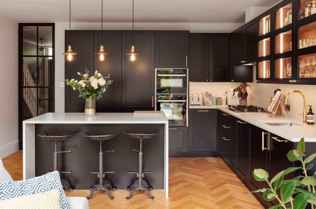 a kitchen with black cabinets and white countertops